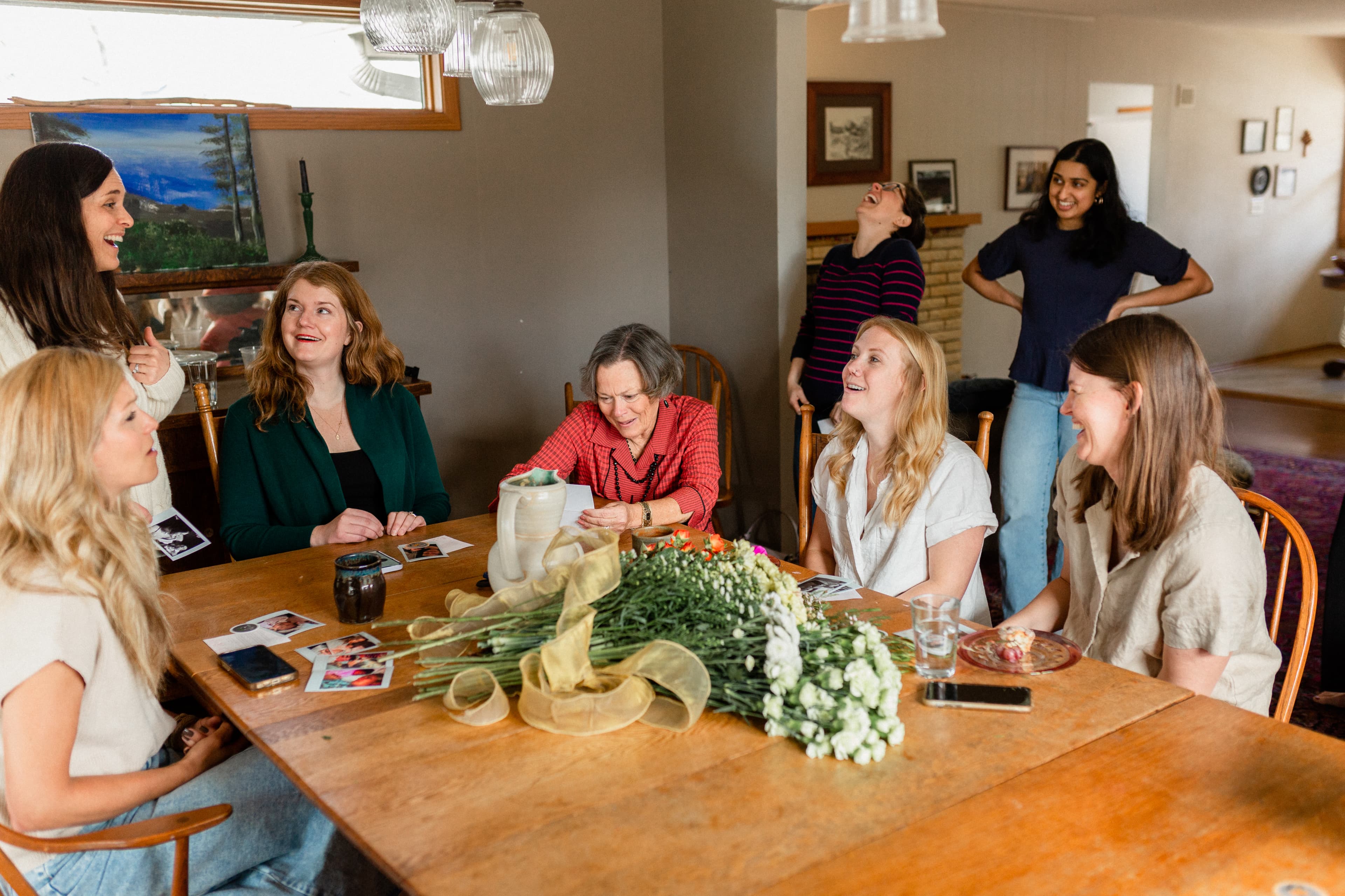 women laughing together around a kitchen table